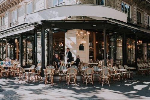 Typical view of Paris street with brasserie (cafe) tables in Paris, France. Architecture and landmarks of Paris. paris postcard