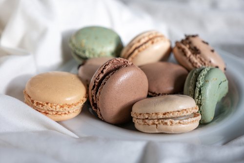 French Colorful Macarons Colorful Pastel Macarons on White Background green beige and Brown Macaron on plate dessert Sweet and colourful french macaroons pastry